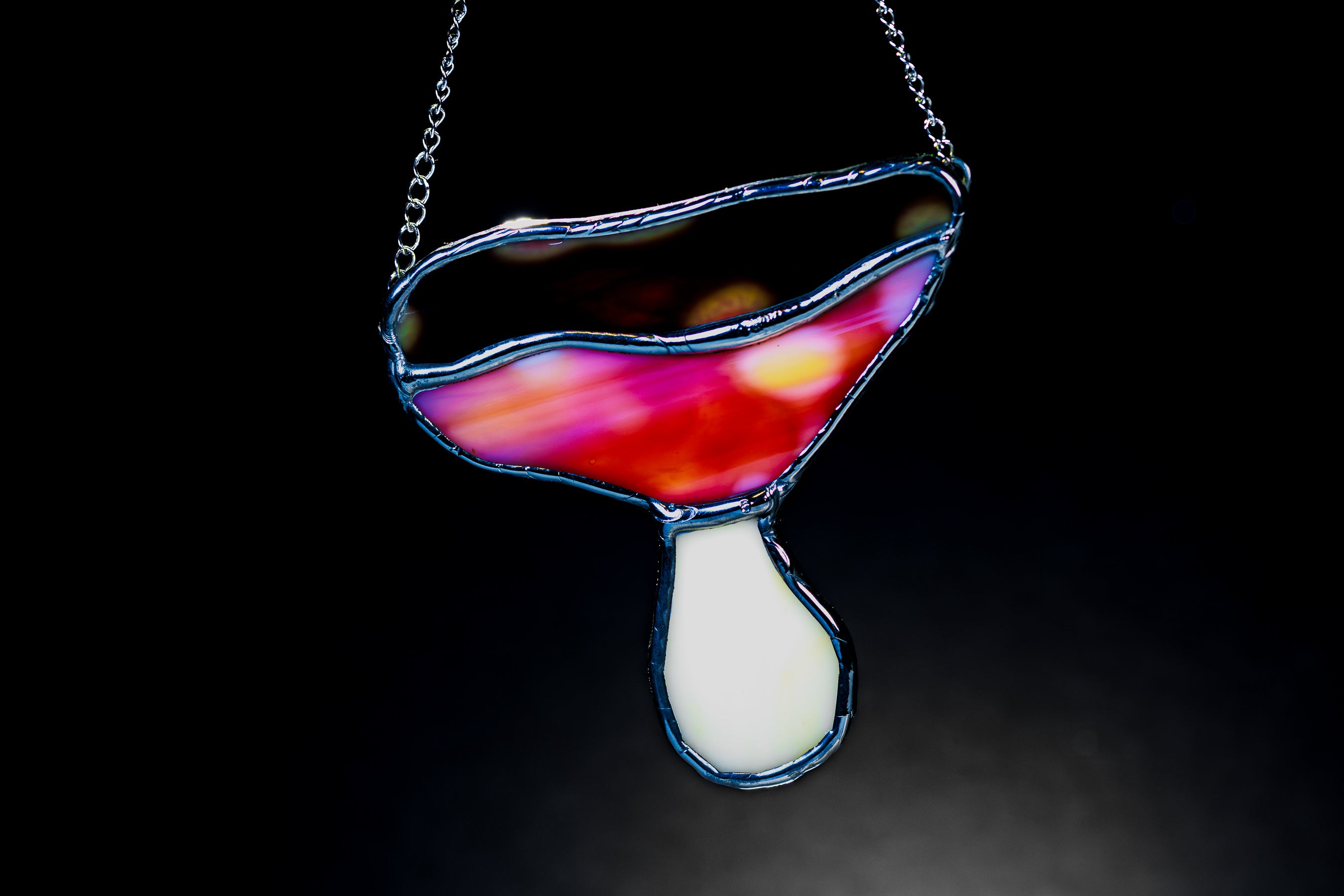 Colorful mushroom-shaped pendant on a dark background